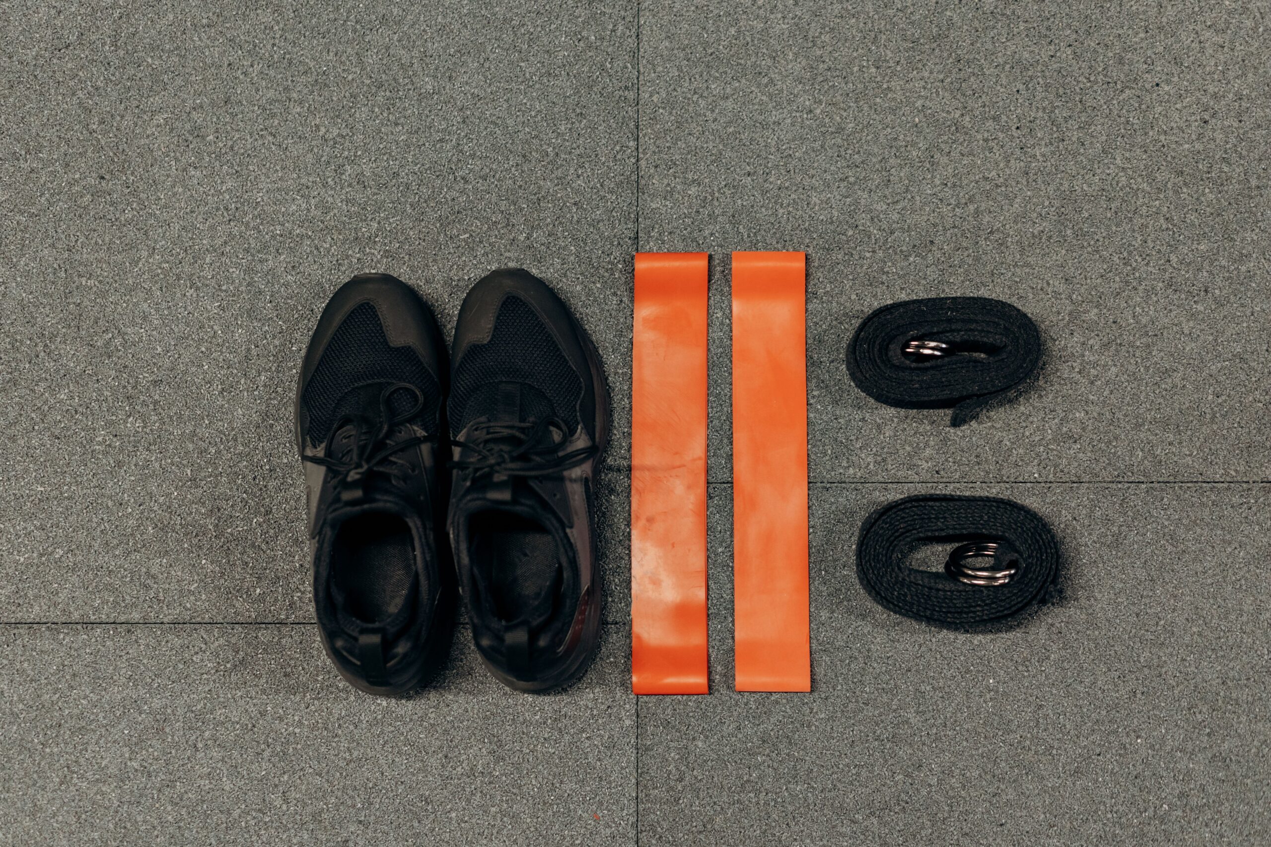 Gym accessories flat lay - shoes, resistance bands, earbuds